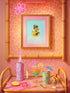 A chic rubber duck styled like Audrey Hepburn’s Holly Golightly, wearing a high bun, yellow bow, black gloves, and a sparkly choker. The duck floats in a pile of foam and is framed in white on a bubbly bathroom shelf with a red tile backdrop and soap dispenser.